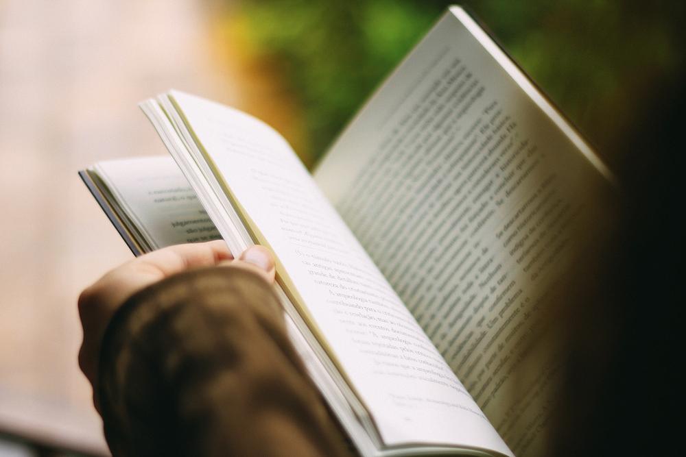 A person leafing through a book. 